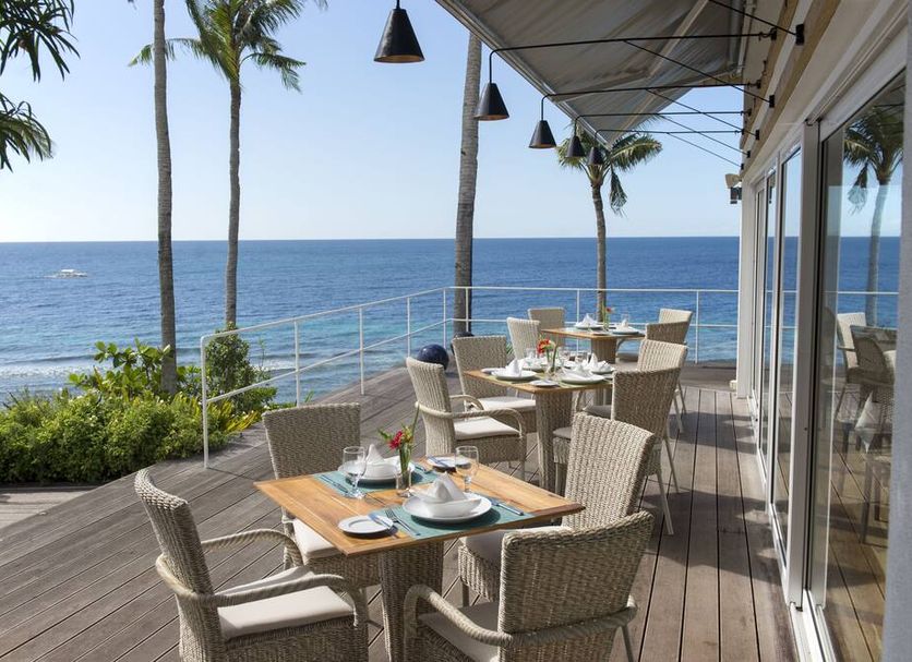 Donatela Resort & Sanctuary in Panglao: oceanfront terrace dining with sea views and palm trees