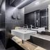 Hotel Bulgaria in Burgas bathroom with black tile, floating sink, large mirror, and a bathtub