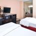 La Bonita Inn & Suites - Mccamey room with two beds, desk, TV and sink area in McCamey