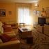 Hotel Stella di Mare in Bečići, warm living room with sofa, coffee table, TV, and sheer-curtained balcony door