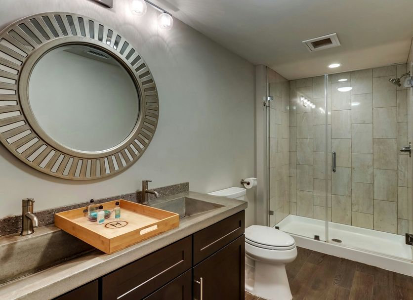The Mantissa Hotel, Hartsville: modern bathroom with walk-in glass shower, vanity, and round mirror