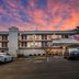Red Roof Inn Baltimore South - Glen Burnie exterior at dusk with parked cars and colorful sky