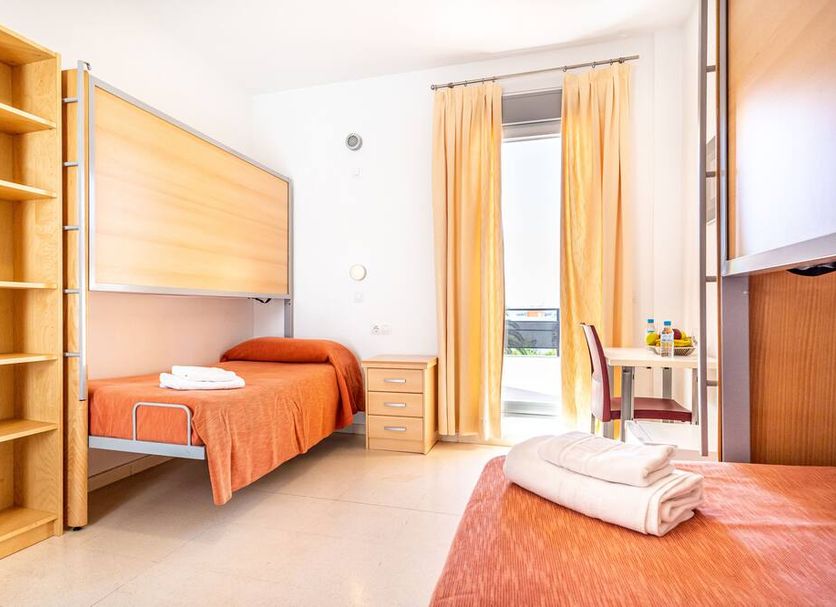 Albergue Inturjoven Marbella in Marbella with a bunk bed, twin bed, desk and balcony door