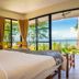 The River Resort in Champasak guest room with king bed and sliding doors to river-view balcony