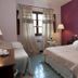 Hotel Ristorante Molino D'era in Volterra: cozy guest room with double bed, purple wall, and window curtains
