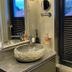 Country-Suites By Verdino Living - Apartments & Privatzimmer bathroom with stone sink, mirror and window in Braunlage