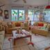 Hale Kawehi Bnb Guesthouse in Hilo living room with sofas, coffee table, stained-glass windows and clocks