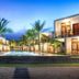 Arugambay Roccos in Arugam: palm-lined pool courtyard with modern villa-style rooms at dusk
