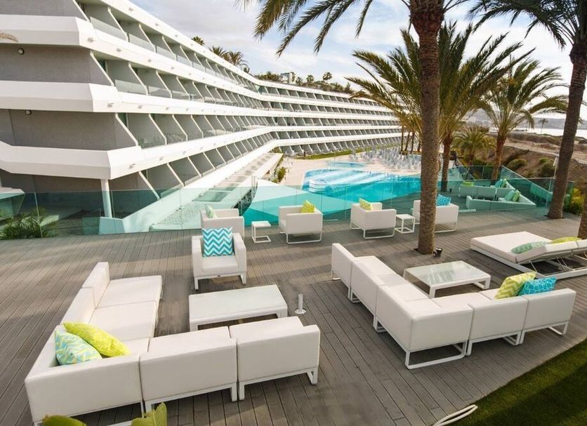 Santa Monica Suites Hotel in Maspalomas with pool, palm trees, and ocean-view terrace seating