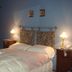 Hotel Beltran room with double bed, lamps, and antique wardrobe in Colonia del Sacramento