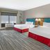 Hampton Inn Junction City guest room with two double beds, window and chair