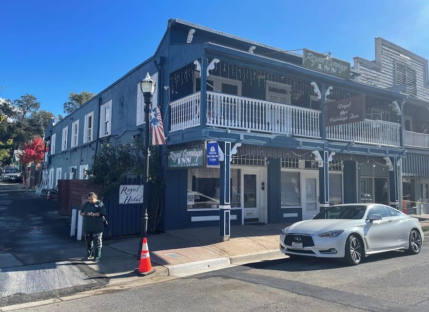 Americas Best Value Inn & Suites Royal Carriage in Jamestown, historic two-story building with balcony and street view