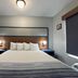 AmericInn by Wyndham Galesburg guest room with king bed and bedside lamps