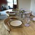 Dining table set for six at Robeanne House in Beverley, with lounge seating visible in the background.