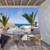 Arkasa Palace in Arkása terrace with dining table, lounge chairs and sea views
