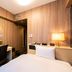 Koko Hotel Asahikawa Station room with desk, chair, bed, and warm wood-paneled walls in Asahikawa