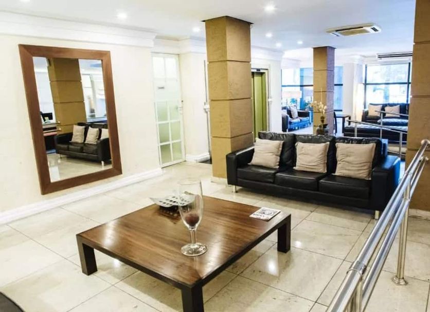 Diamond Hotel in Rio de Janeiro lobby with black sofa, wood coffee table, mirrors and bright seating area
