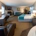 Paynesville Inn And Suites in Paynesville room with king bed, sofa, desk, fireplace and jetted tub