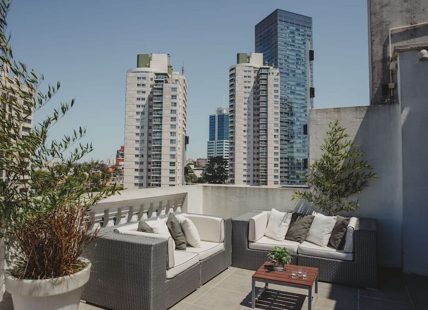 After Hotel Montevideo rooftop terrace with lounge seating and Montevideo skyline views