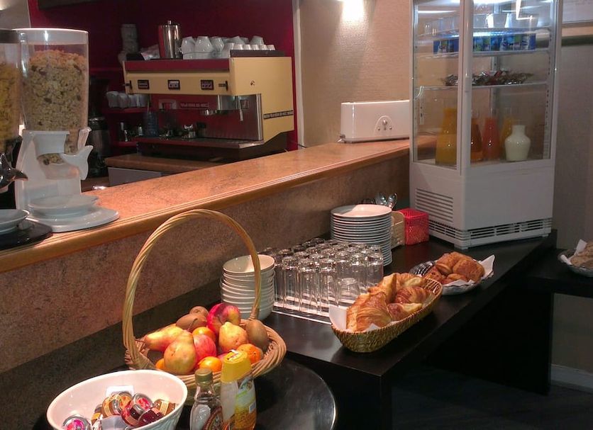 Breakfast buffet at Hôtel des Ambassadeurs in Toulouse with fruit, pastries, glasses and coffee machine