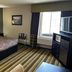 Super 8 by Wyndham Mound City guest room with king bed, TV, window and striped carpet