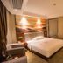 Wuyue Yuexin Hotel (Jinggangshan) guest room with king bed, mountain mural, and seating area in Ji'an
