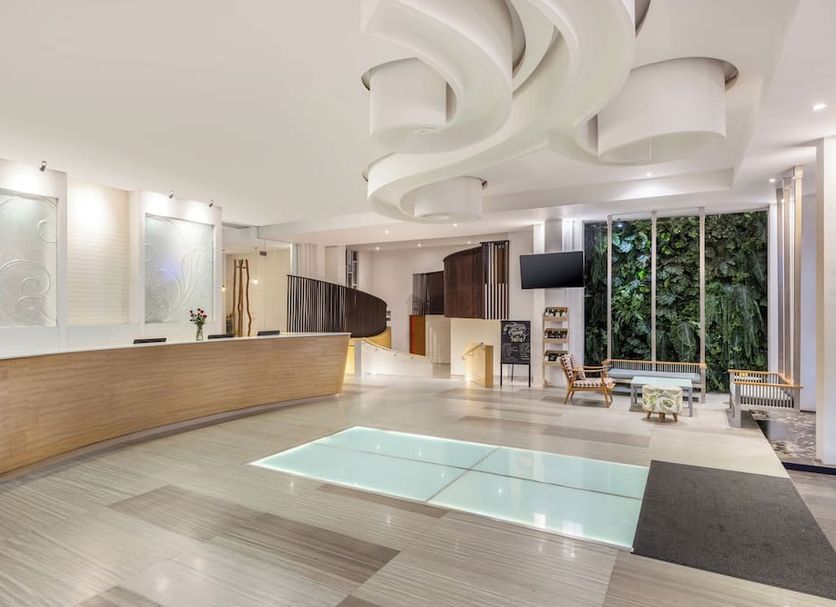 Harris Hotel & Residences Sunset Road lobby in Kuta with modern reception desk and glass floor feature