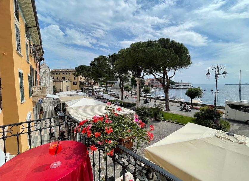 Hotel & Restaurant San Marco Ab terrace with lakefront view in Toscolano Maderno, flowers and umbrellas