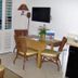 Islander Beach Resort New Smyrna Beach room with table, chairs, wall TV and plantation shutters