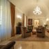 Palazzo San Lorenzo in Colle di Val d'Elsa, elegant lounge with chandelier, armchairs and staircase