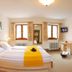 Gästehaus Enzianhof Hotel Garni in Oberammergau room with bed, sofa, windows, and TV