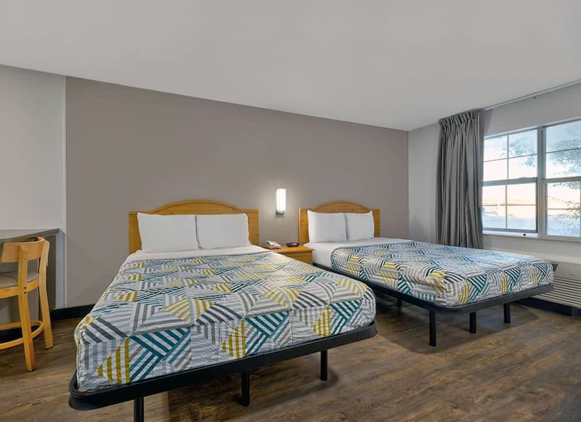 Studio 6 Ft Worth - North Richland Hills room with two beds, desk, and window view