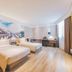 Binhai Jianguo Hotel in Tianjin guest room with two beds, desk, and large mural wall