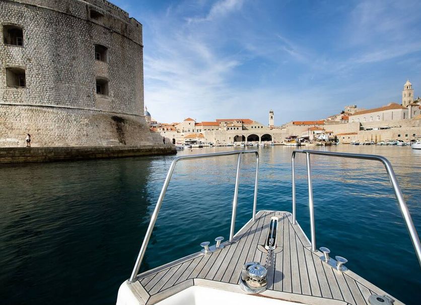 Pervanovo Apartments in Dubrovnik with boat-front view of the walled harbor and old town skyline