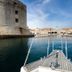 Pervanovo Apartments in Dubrovnik with boat-front view of the walled harbor and old town skyline
