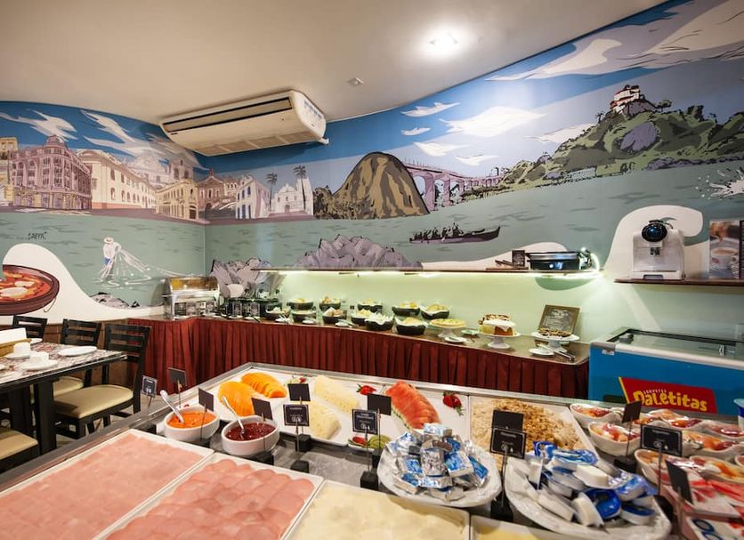 Slaviero Vitória breakfast buffet with food display and scenic mural wall in Vitória