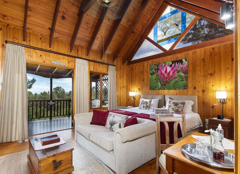 Arendsrus Country Resort in George: wood-paneled suite with balcony, king bed, sofa and mountain views