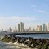 Guijo Suites Makati in Makati with city skyline and waterfront view beyond a rocky breakwater