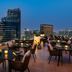 Sheraton The Walk, Dubai rooftop terrace with dining tables and city skyline views at dusk