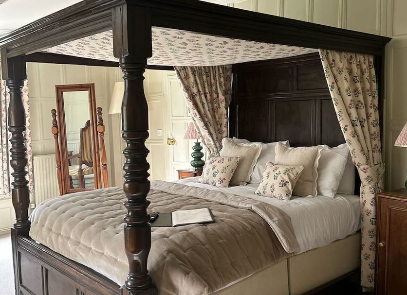 Ravenwood Hall Hotel in Bury St. Edmunds, four-poster bed with floral curtains and bedside lamps