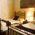 Las Iglesias Antigua guest room with two wrought-iron beds, bedside lamp and wardrobe