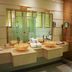 AG Hotel Abu Dhabi bathroom vanity with double sinks, large mirror and glass shower enclosure