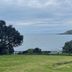 Lottin Point Motel in Hicks Bay with ocean views, grassy lawn, trees, and distant coastline