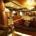 Welcome Hotel at Srinagar lobby with carved wood seating, chandelier and warm lighting in Srinagar