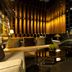 Quentin Boutique Hotel Berlin lounge with warm wood paneling, sofas, armchairs and a glass coffee table