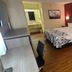 Red Roof Inn & Suites Cornelius - Lake Norman room with bed, sofa, desk and wood-look flooring in Cornelius