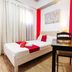 RedDoorz near Quirino Station Manila room with bed, desk, curtains, and red accent walls