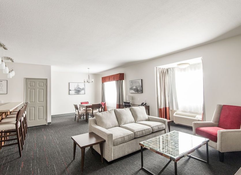 Edgewater Hotel Whitehorse living room with sofa, glass coffee table, dining table and chairs