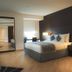 Asdal Boutique Hotel Seef in Manama guest room with king bed, bedside lamps and modern dark accent wall