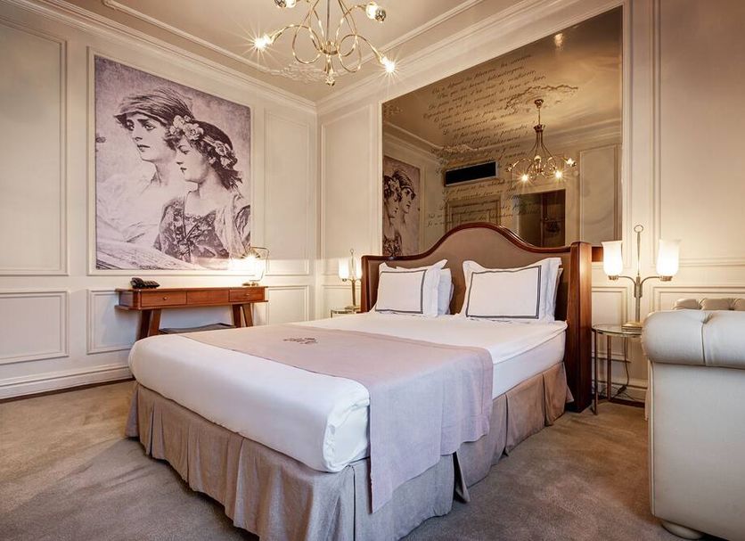 Galata Antique Hotel Istanbul bedroom with king bed, chandelier, and vintage wall art